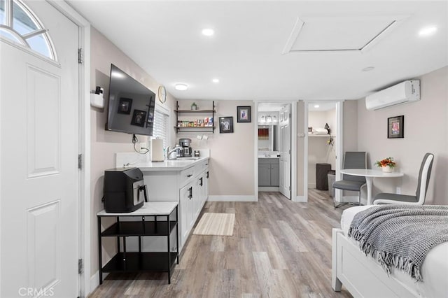 interior space with open shelves, light countertops, an AC wall unit, white cabinets, and light wood-type flooring