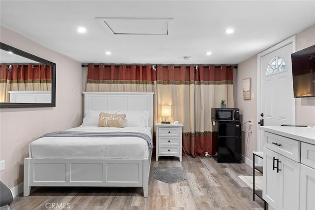 bedroom with black fridge, recessed lighting, attic access, and light wood-style floors