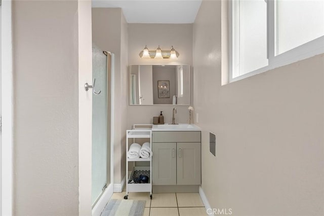 bathroom featuring baseboards, a stall shower, vanity, and tile patterned floors