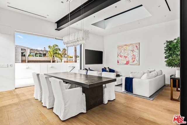 dining area featuring light hardwood / wood-style flooring and a chandelier