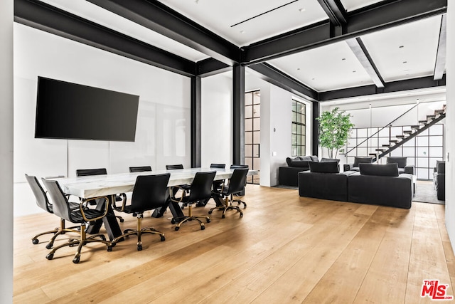 dining space with beam ceiling and light hardwood / wood-style flooring