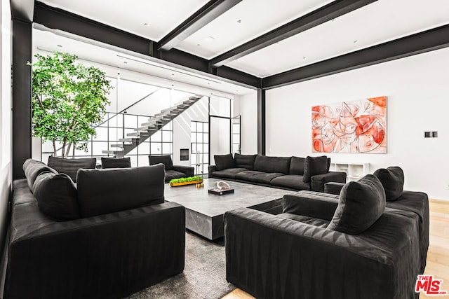 living room featuring beamed ceiling and hardwood / wood-style flooring