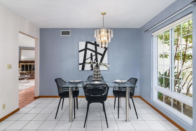 dining room featuring tile patterned floors, baseboards, visible vents, and a chandelier