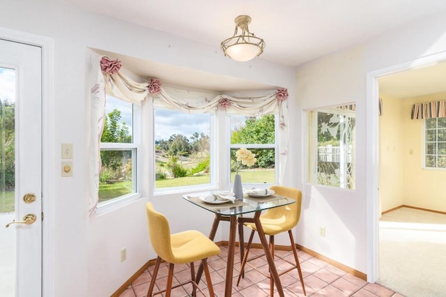 dining space featuring light tile patterned floors and baseboards