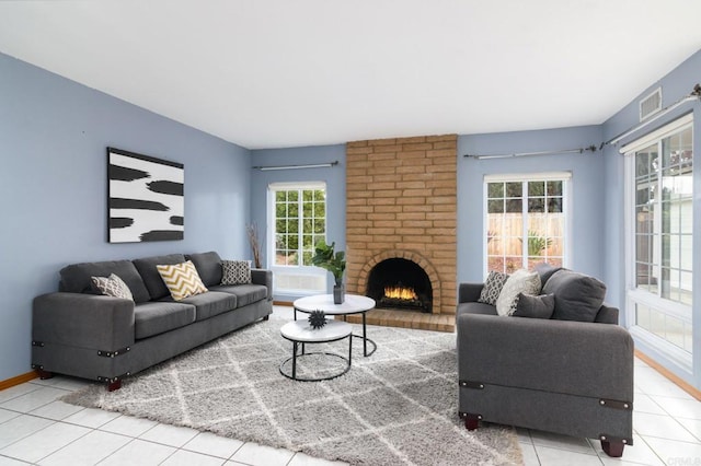 tiled living area featuring a fireplace, visible vents, and baseboards