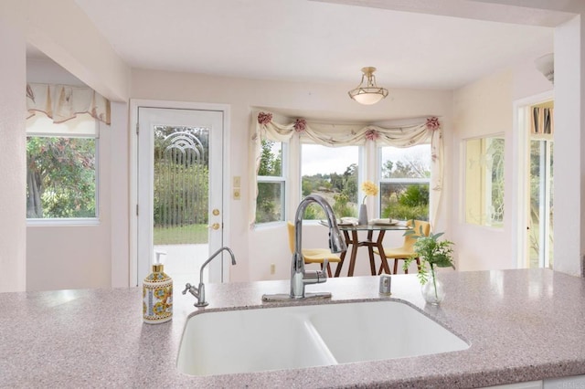 kitchen with light stone countertops and a sink