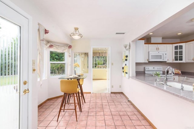 dining room featuring light tile patterned floors, visible vents, and baseboards