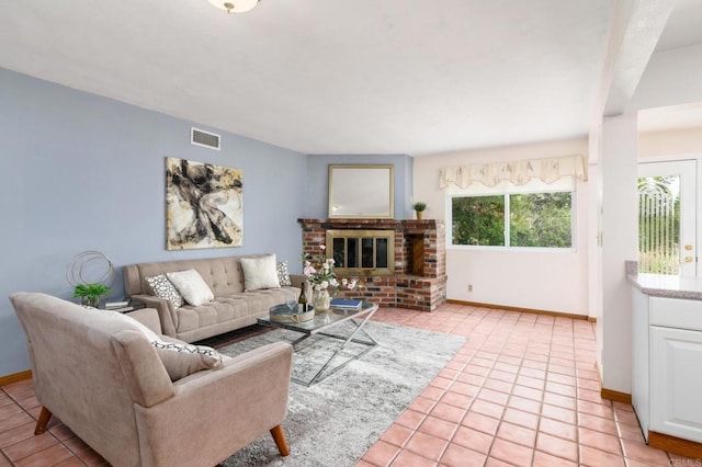 living area featuring light tile patterned floors, visible vents, baseboards, and a fireplace