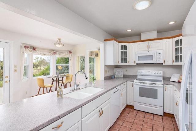 kitchen featuring glass insert cabinets, light tile patterned floors, white cabinets, white appliances, and a sink