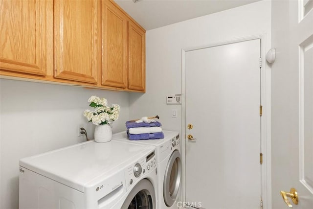 washroom with cabinet space and washer and clothes dryer