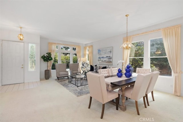 dining area featuring light carpet, a chandelier, and a healthy amount of sunlight