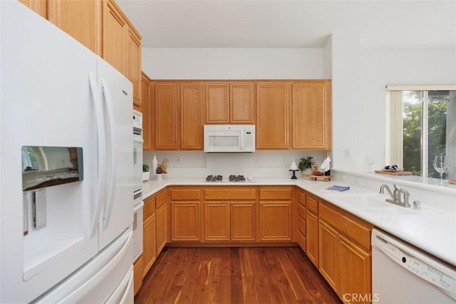 kitchen featuring white appliances, light countertops, a sink, and dark wood-style flooring