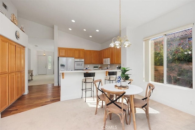 dining space featuring a notable chandelier, recessed lighting, light carpet, high vaulted ceiling, and baseboards