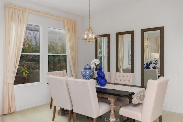 carpeted dining room with a notable chandelier and baseboards