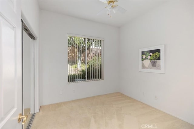 unfurnished bedroom with ceiling fan, a closet, and light colored carpet