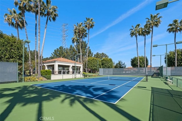 view of tennis court with fence and a gazebo