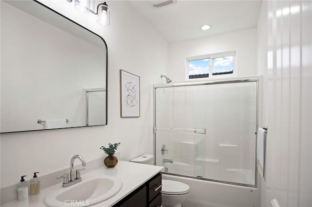 full bathroom with toilet, vanity, and bath / shower combo with glass door