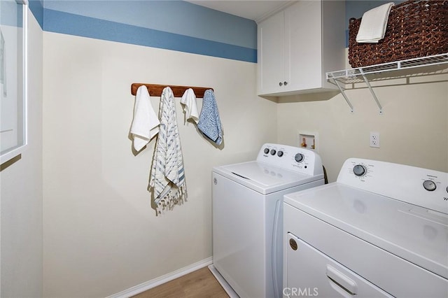 laundry room featuring cabinets, light wood-type flooring, and independent washer and dryer