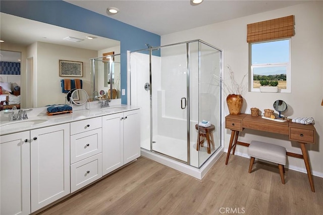 bathroom with vanity, wood-type flooring, and walk in shower