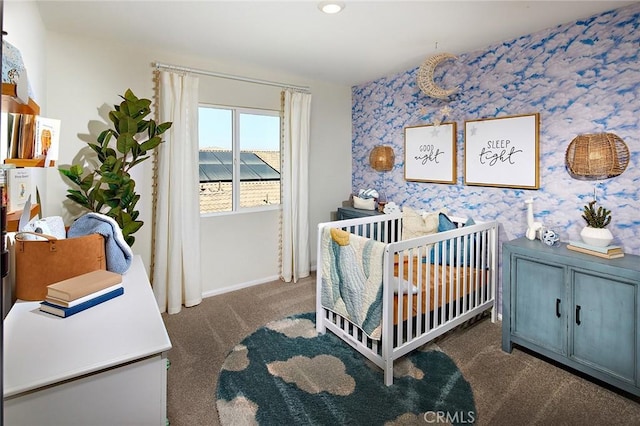 carpeted bedroom featuring a nursery area