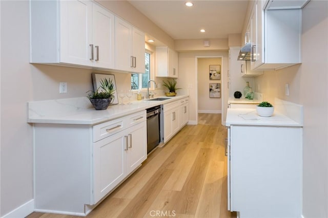 kitchen featuring white cabinetry, dishwasher, sink, light stone counters, and light hardwood / wood-style floors