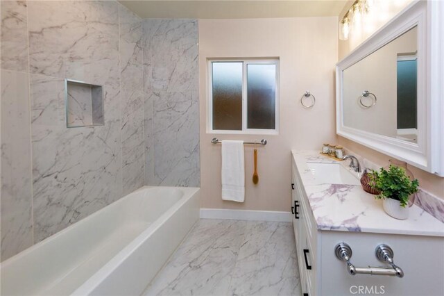 bathroom featuring vanity and tiled shower / bath