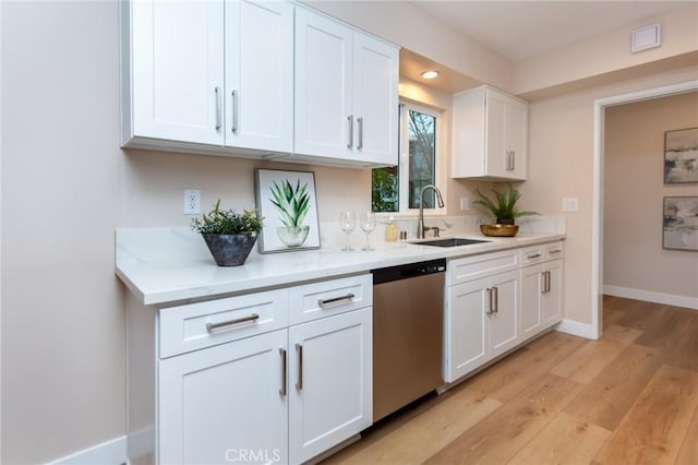 kitchen featuring white cabinetry, dishwasher, sink, and light wood-type flooring