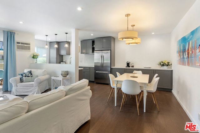 dining area with dark hardwood / wood-style flooring and a wall unit AC