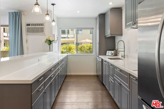 kitchen featuring stainless steel appliances, sink, gray cabinetry, and decorative light fixtures