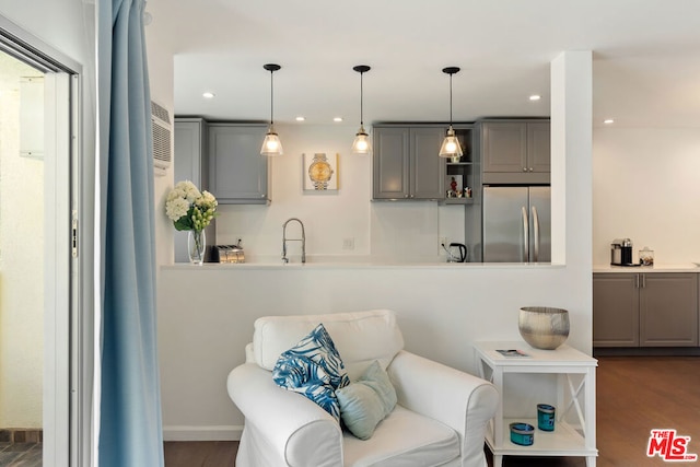 interior space featuring gray cabinets, sink, stainless steel fridge, dark hardwood / wood-style flooring, and hanging light fixtures