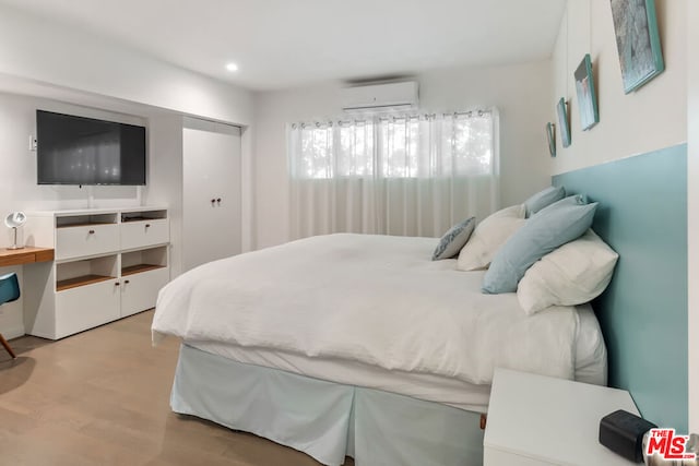 bedroom featuring an AC wall unit and light wood-type flooring