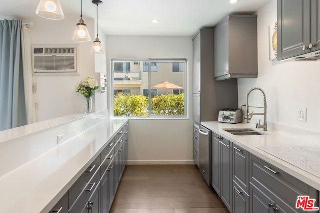 kitchen featuring gray cabinetry, sink, pendant lighting, and an AC wall unit