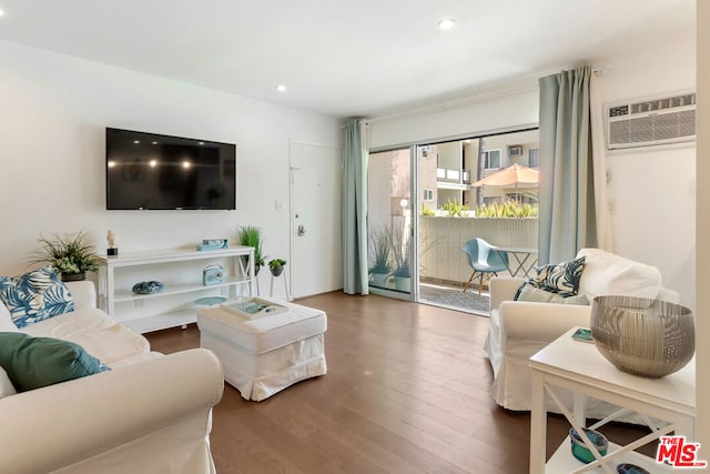 living room with hardwood / wood-style floors and a wall unit AC