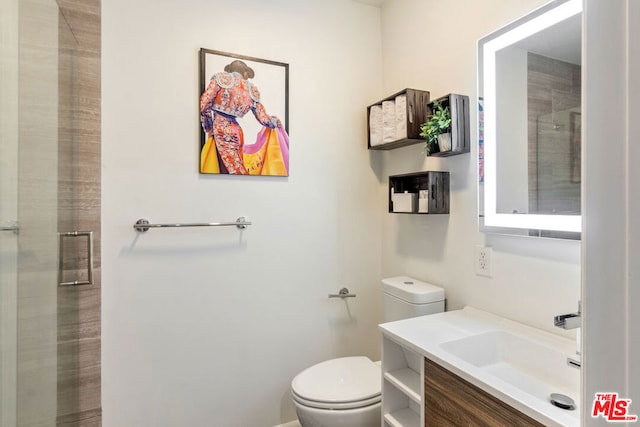 bathroom with vanity, a shower with shower door, and toilet