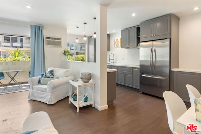 kitchen featuring pendant lighting, dark wood-type flooring, gray cabinetry, and stainless steel fridge