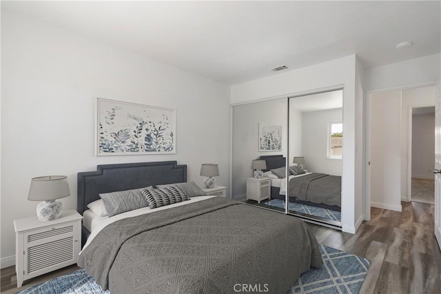 bedroom featuring dark wood-type flooring and a closet