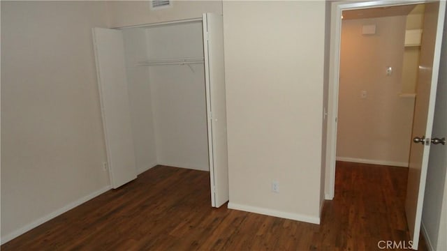 unfurnished bedroom with a closet and dark hardwood / wood-style floors