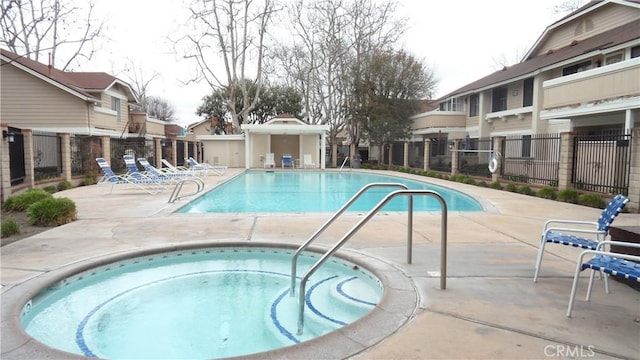 view of pool with a hot tub and a patio