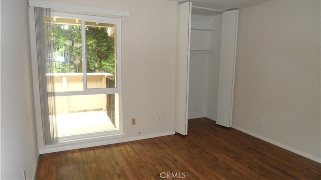 unfurnished bedroom featuring a closet and dark hardwood / wood-style floors