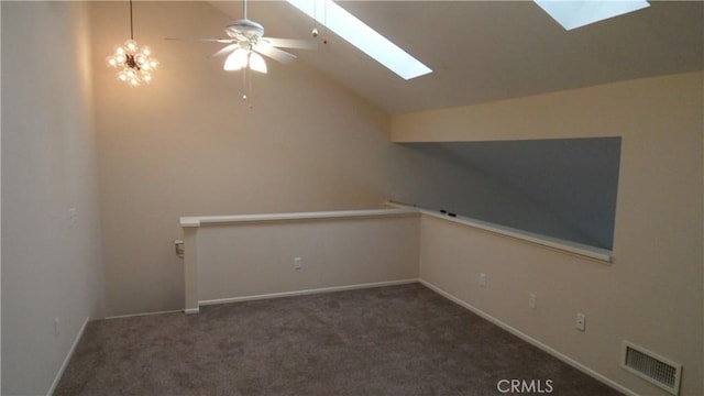 additional living space with ceiling fan, vaulted ceiling with skylight, and dark colored carpet