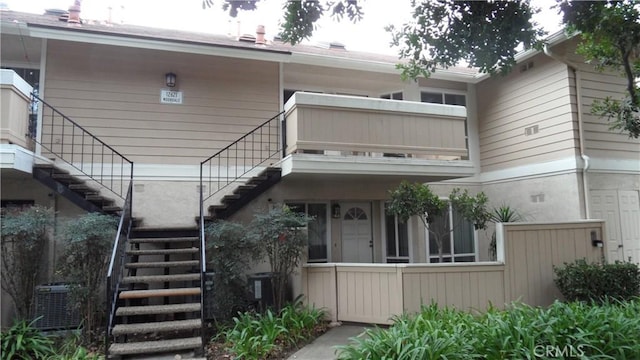 view of front of property with a balcony and central air condition unit