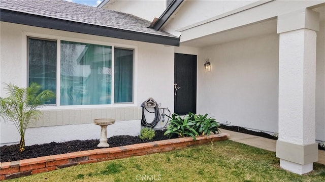 entrance to property featuring a lawn