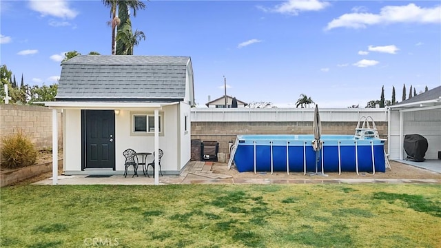 view of outbuilding with a fenced in pool and a yard