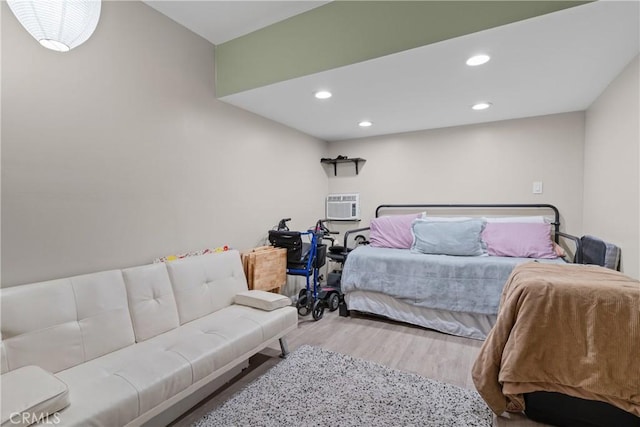 bedroom featuring a wall mounted air conditioner and light hardwood / wood-style floors