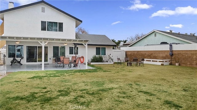 rear view of property with a patio and a lawn