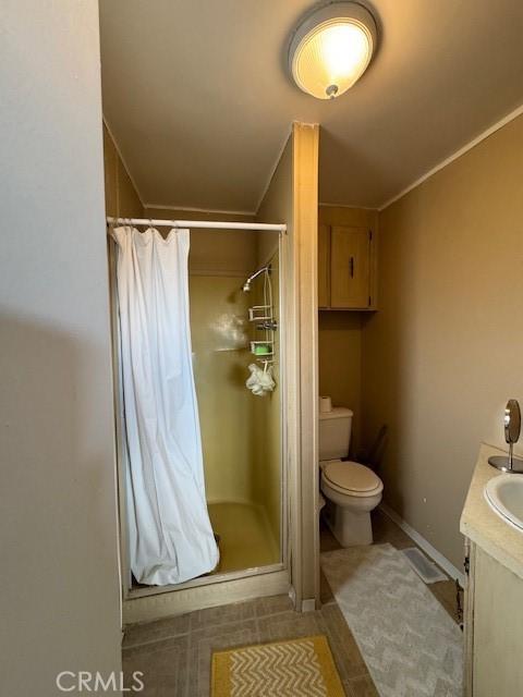 bathroom featuring vanity, crown molding, toilet, and walk in shower