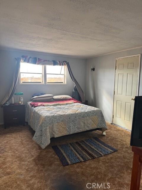 carpeted bedroom featuring a textured ceiling