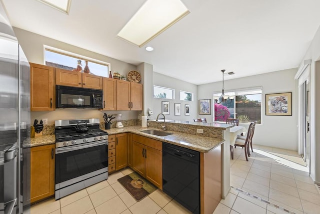 kitchen featuring sink, light tile patterned floors, black appliances, decorative light fixtures, and kitchen peninsula