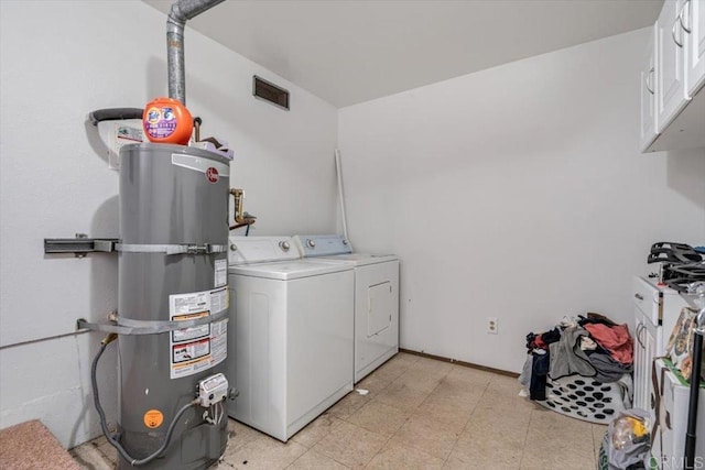 laundry room with cabinets, separate washer and dryer, and secured water heater