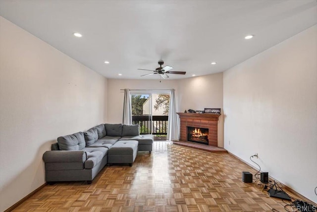 living room featuring a brick fireplace, light parquet floors, and ceiling fan